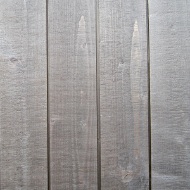 Façade avec bardage vertical à rainures apparentes, coupé à la scie à ruban et muni d’une couche de pré-grisage