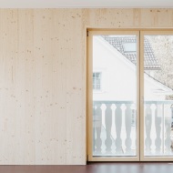 Salon avec mur en bois et portes de balcon