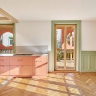 Farbig lackierte Küche mit Holz-Fussboden und grünen Innenausbau-Elementen