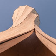 Gros plan en contre-plongée de la tour d’Urbach avec vue vers le ciel. La structure en bois, de forme spéciale et rotative, est ainsi clairement visible