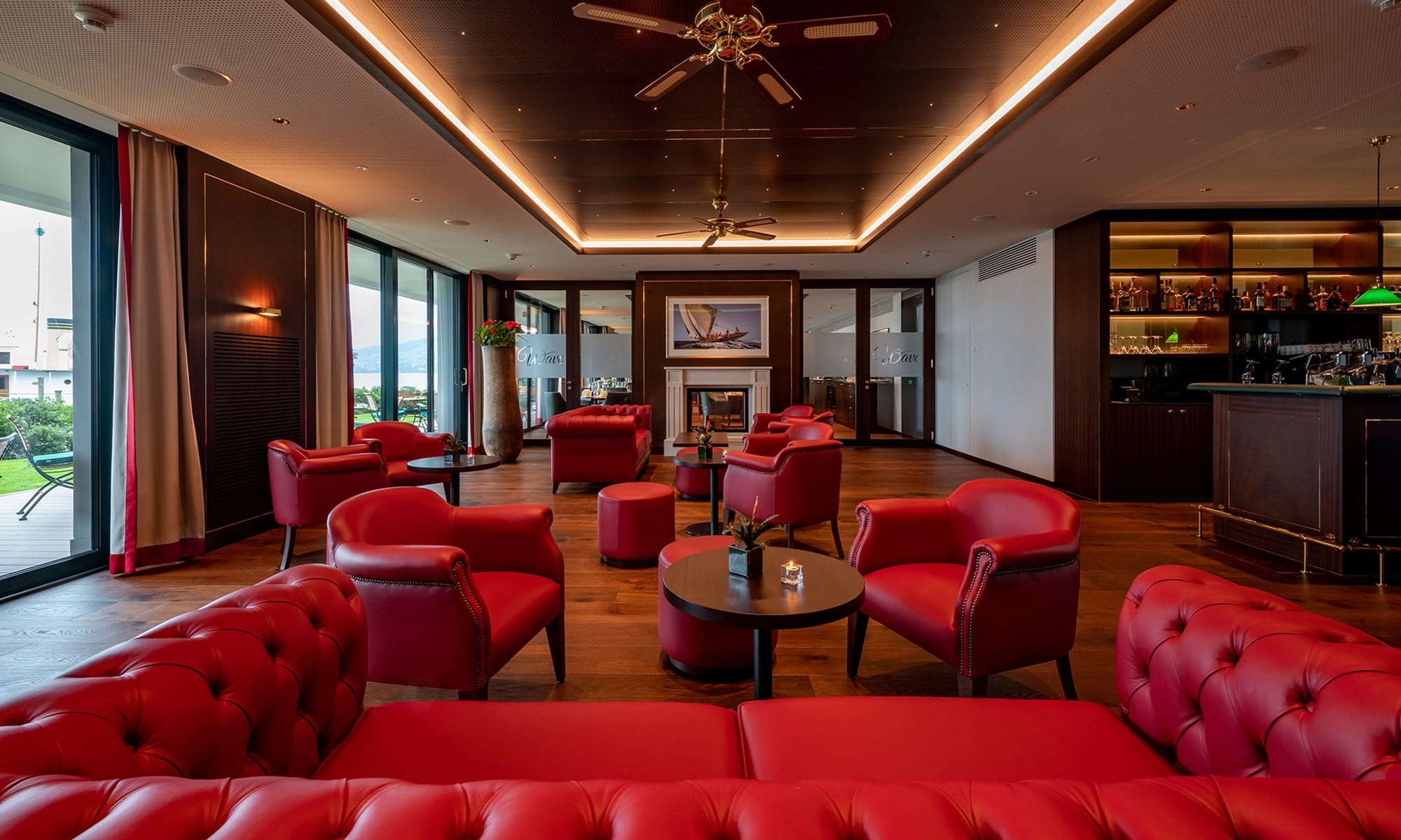 Lounge und Bar im Hotel Bad Horn mit roten Sitzmöbeln und indirekter Deckenbeleuchtung 