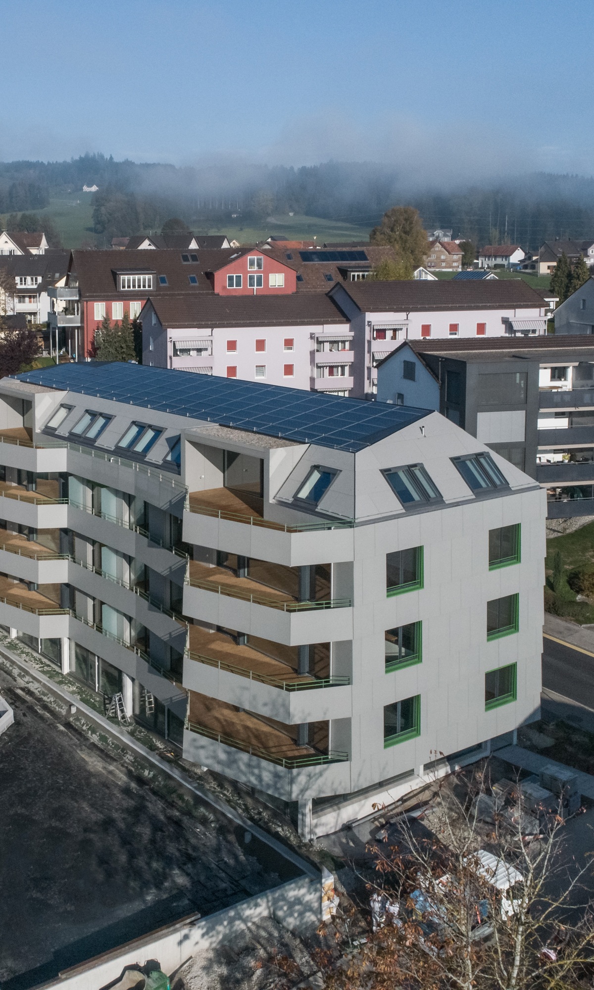 Luftaufnahme des Mehrfamilienhauses Berg mit Sicht auf die mit Holz belegten Terrassenböden der einzelnen Wohnungen