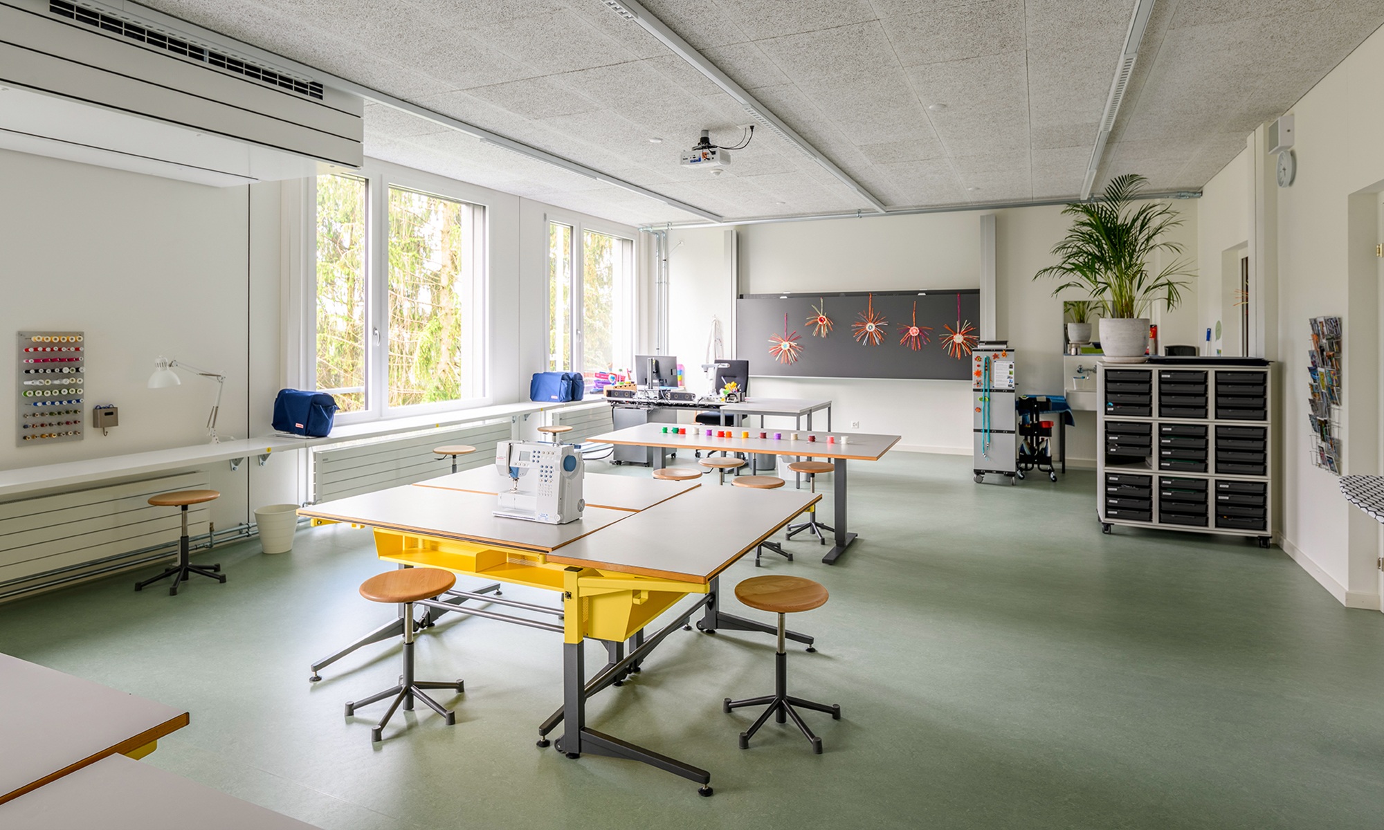 Innenansicht eines Gruppenraumes im Schulhaus Grenzhof Luzern mit Nähmaschine auf dem Tisch