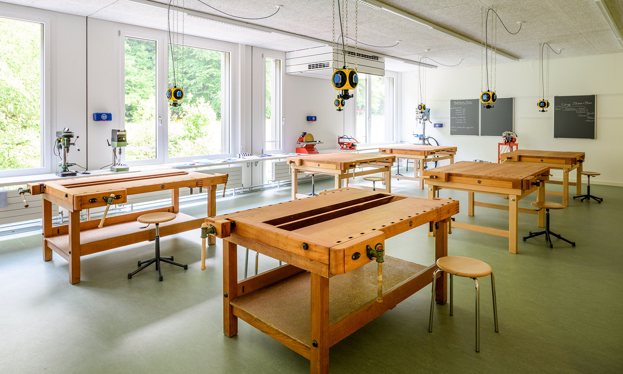 Innenansicht des Werkzimmers im Schulhaus Grenzhof Luzern mit sechs Werkbänken