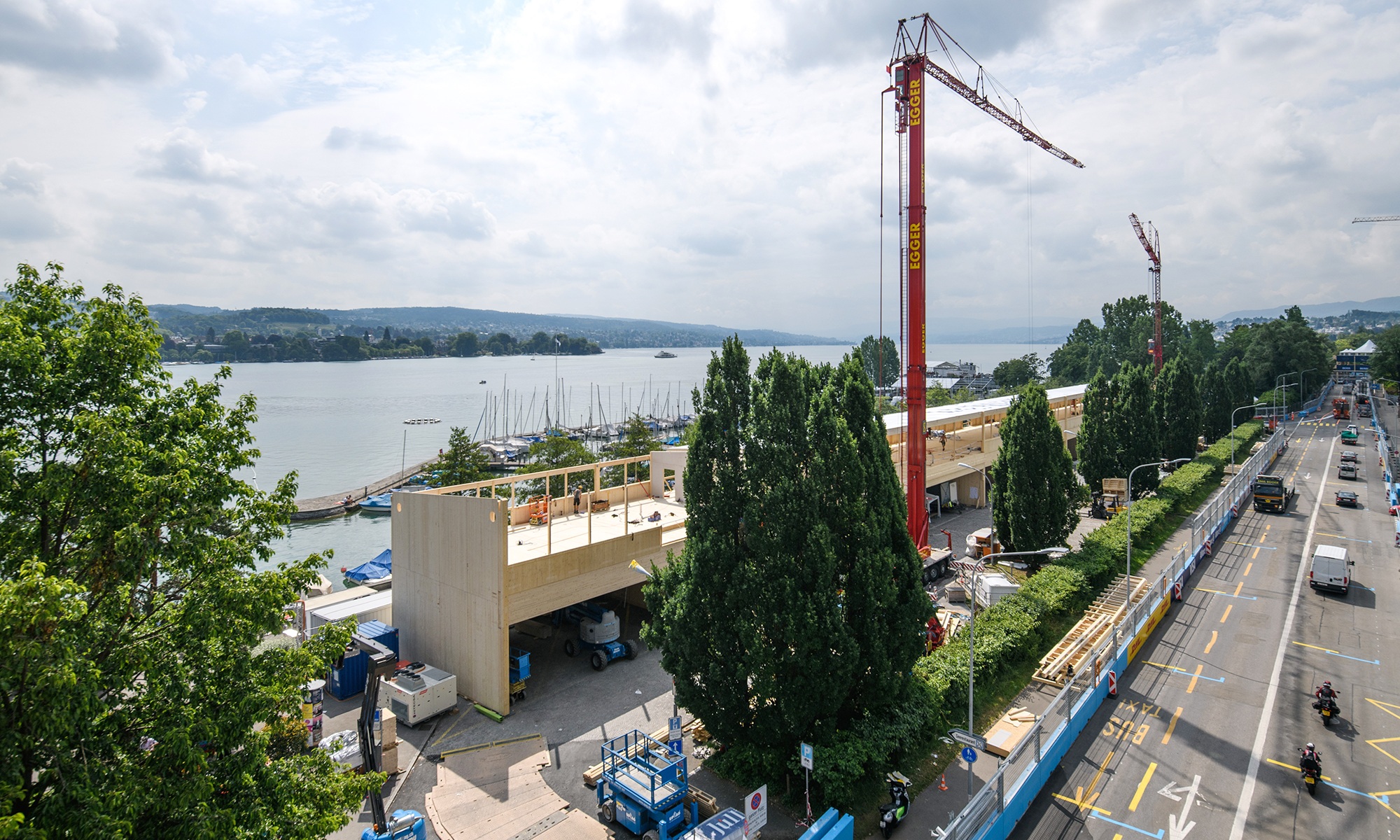 La prise de vue montre l’installation de la formule E à Zurich. En arrière-plan, on voit le lac et l’entrée du port juste derrière le bâtiment événementiel.