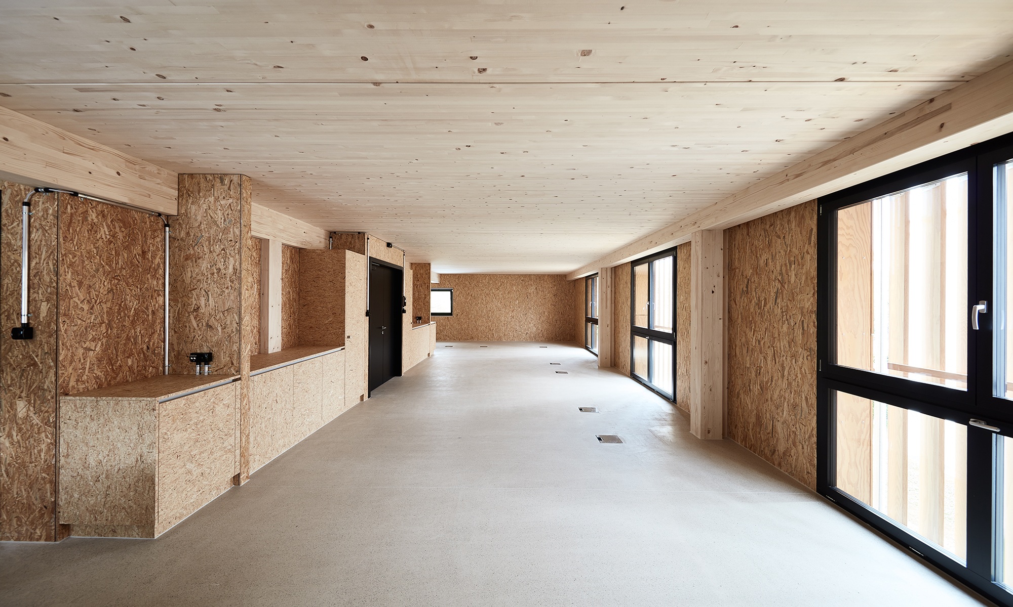 Innenbereich der Industriehalle mit Innenausbau in Holz und Fussboden aus Beton