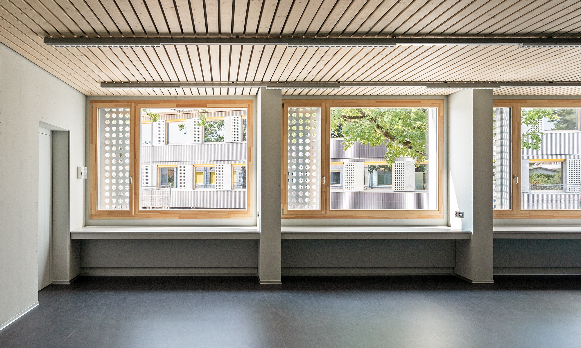 Helles Klassenzimmer mit grossen Fenstern im Schulpavillon Brünnen