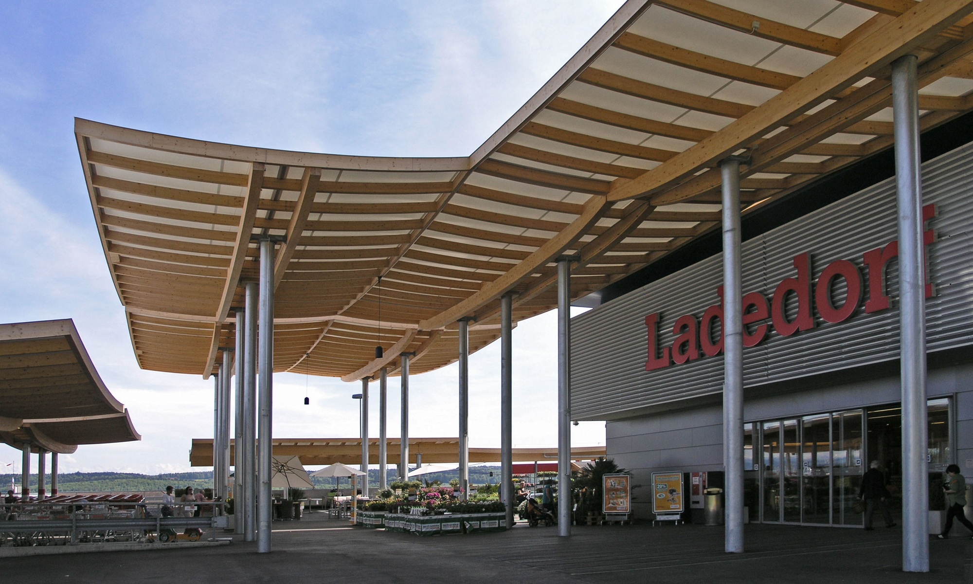 Aufnahme des Eingangsbereichs des Einkaufscenters Ladedorf mit Überdachung aus Holz