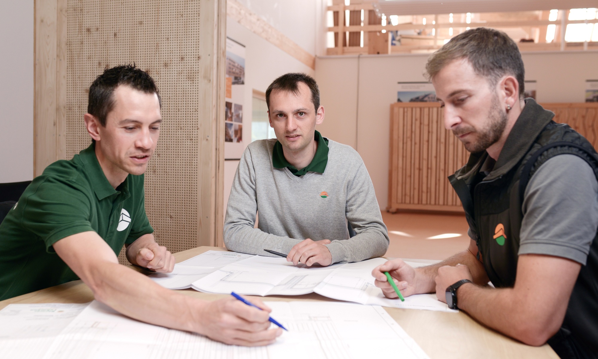 Drei Projektleiter sitzen in einem Büroraum während einer Besprechungssituation