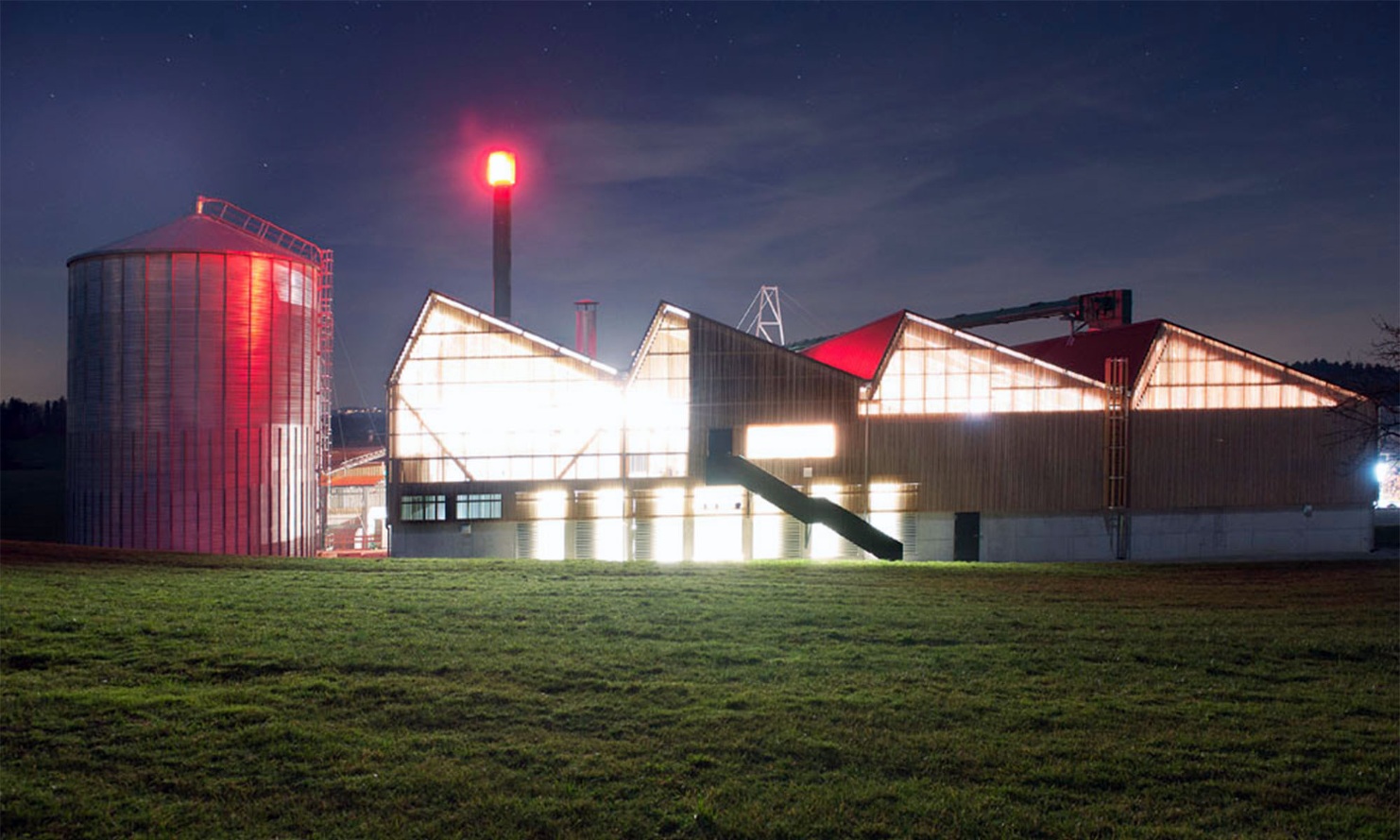 Nachtfoto vom geleuchteten Kraftwerk-Gebäude auf dem Erlenhof