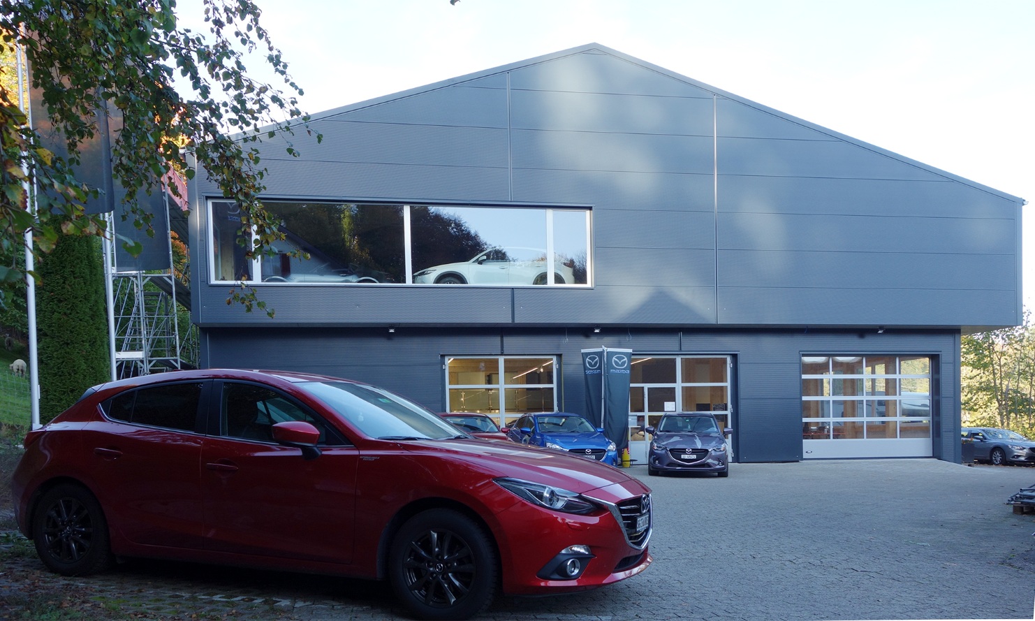 Overall view of the Mazda garage with car parked in front 