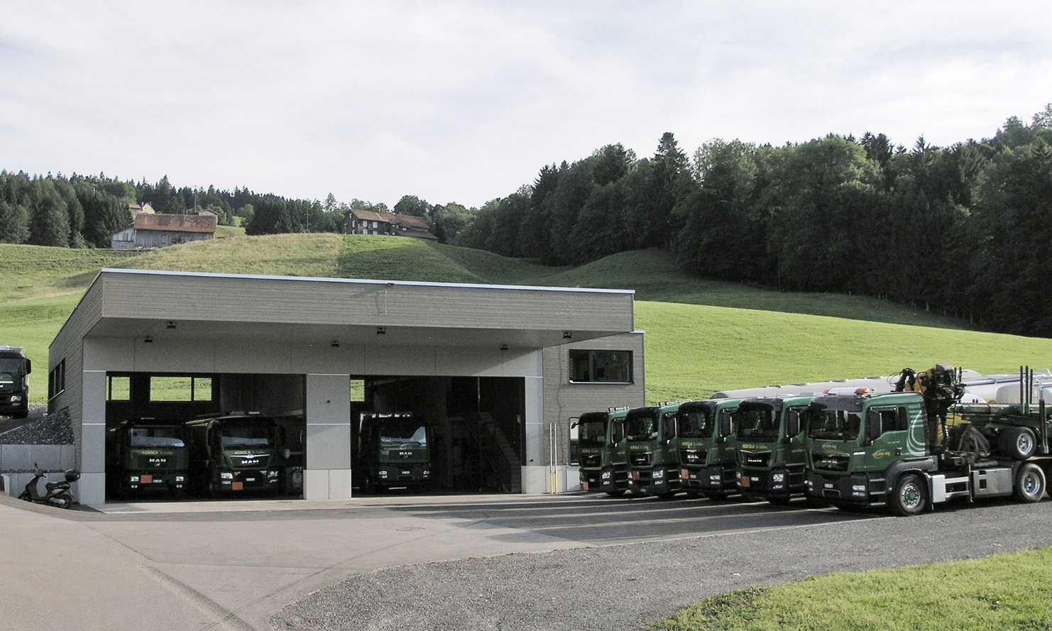 Overall view of the lorry garage with the lorry fleet parked in front.
