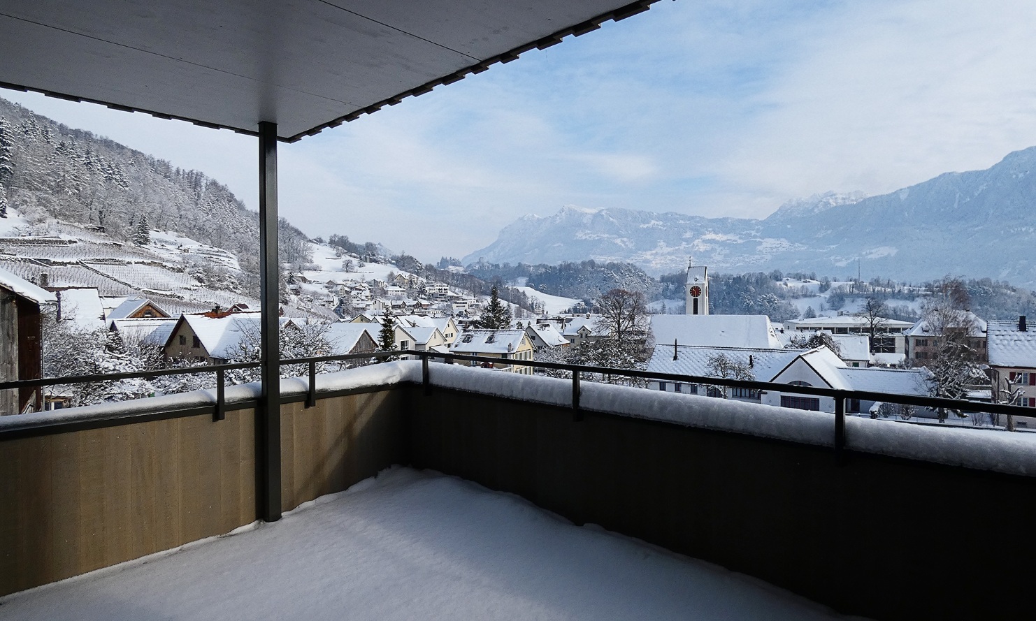 A wintry panorama from one of the apartment building’s balconies, looking towards vineyards, the village and mountains