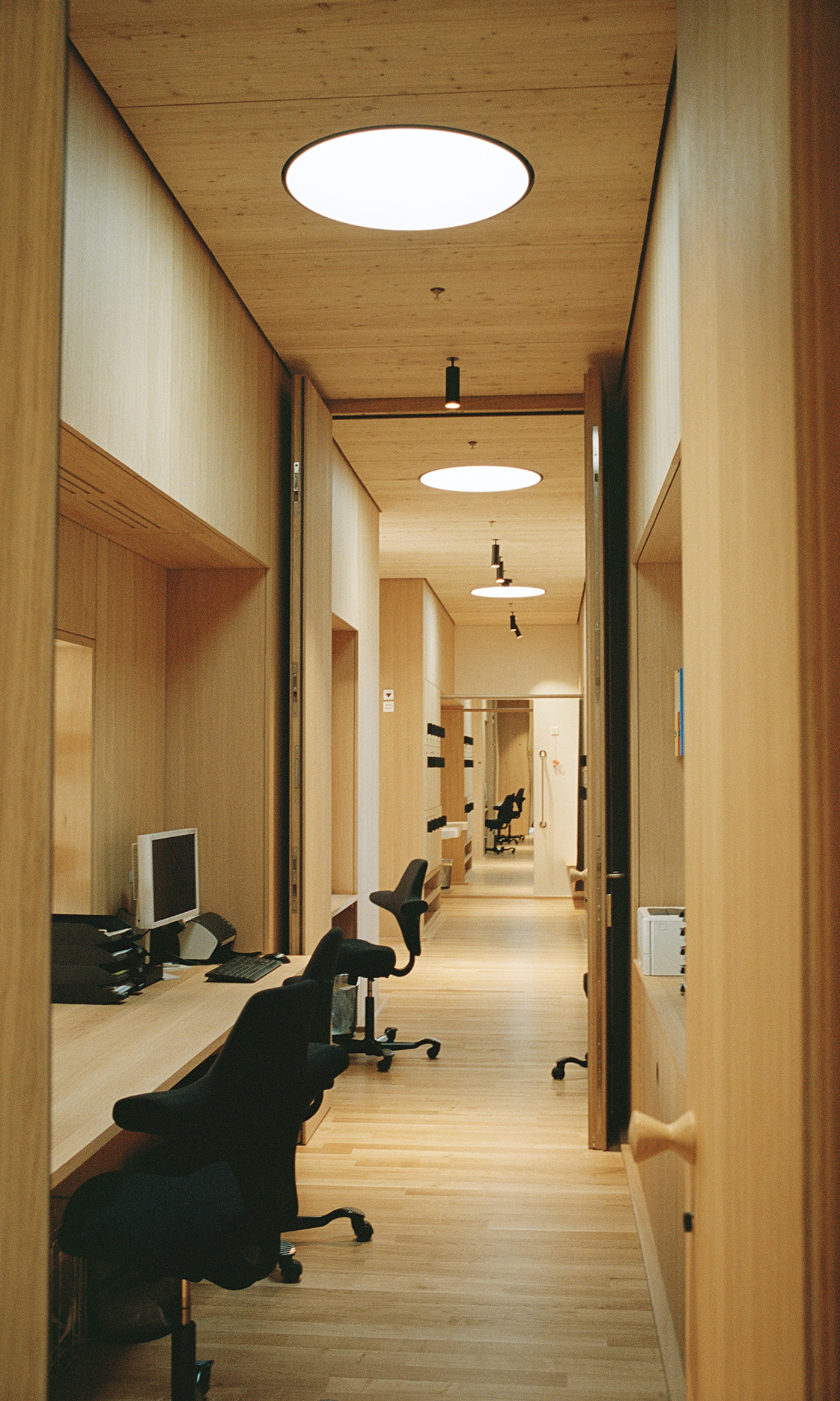 Workstations are arranged side by side in the elongated offices. 