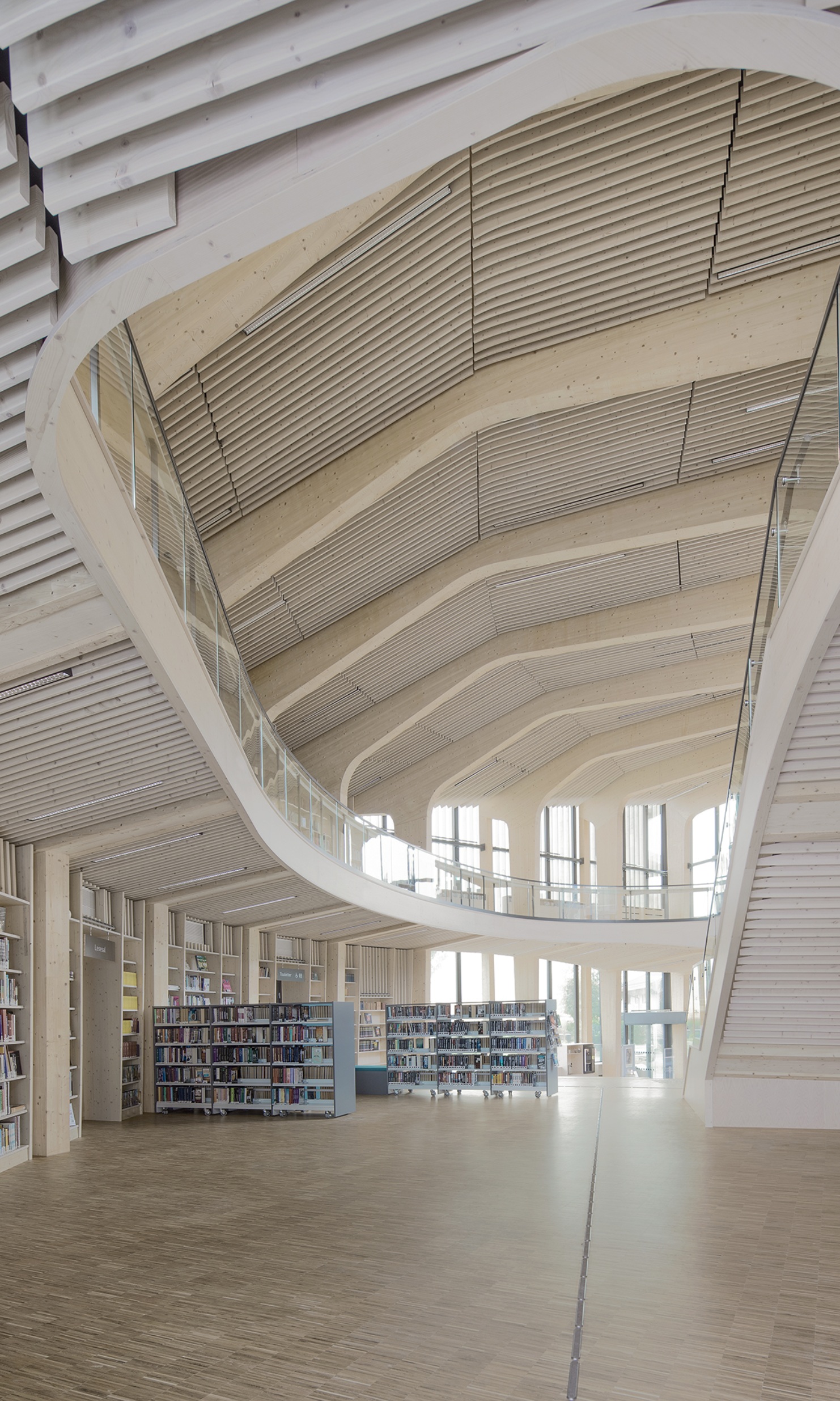 View from the ground floor with bookshelves up to the roof in the library building with its striking timber construction.
