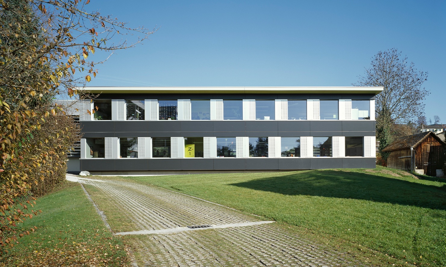 Le pavillon d’école temporaire de deux étages Hasenacker à Männedorf se dresse dans une prairie verdoyante