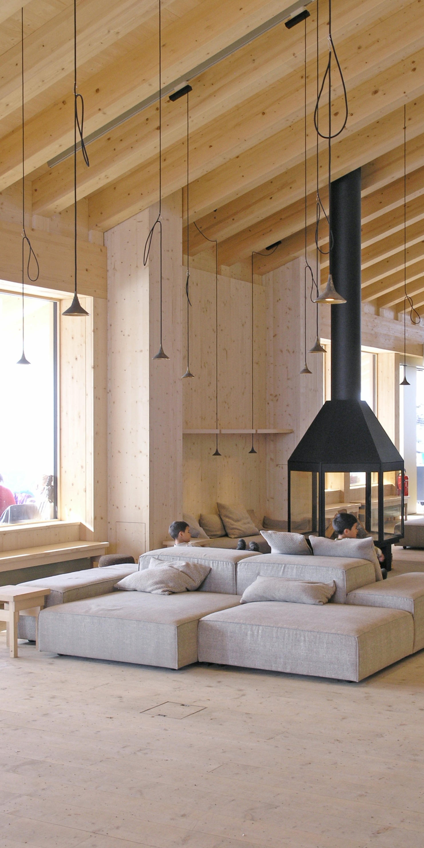Prise de vue d’un coin salon confortable et lumineux avec poêle-cheminée et canapé