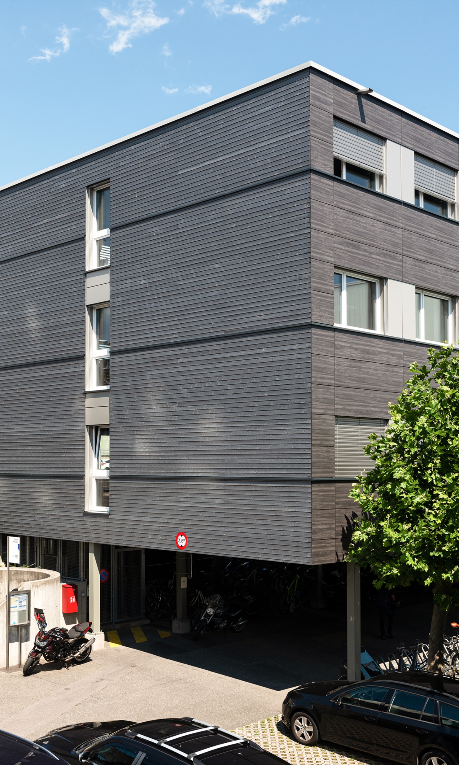 Three-storey modular construction with a dark timber facade seen from the side