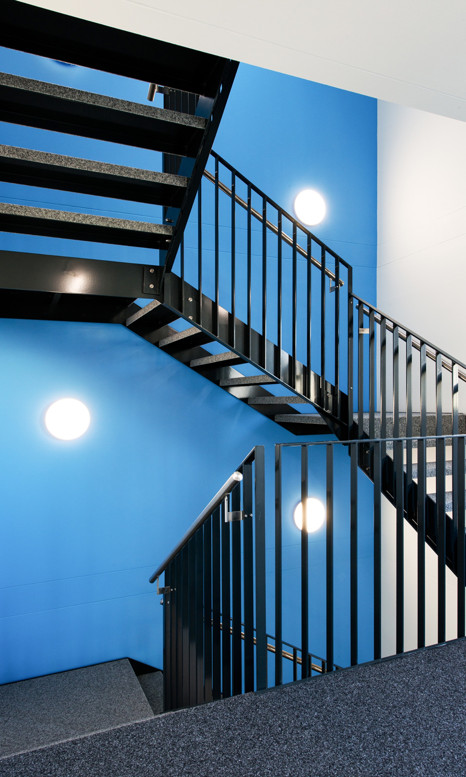 Stairwell with blue walls in the Lausanne transport authority’s temporary office building