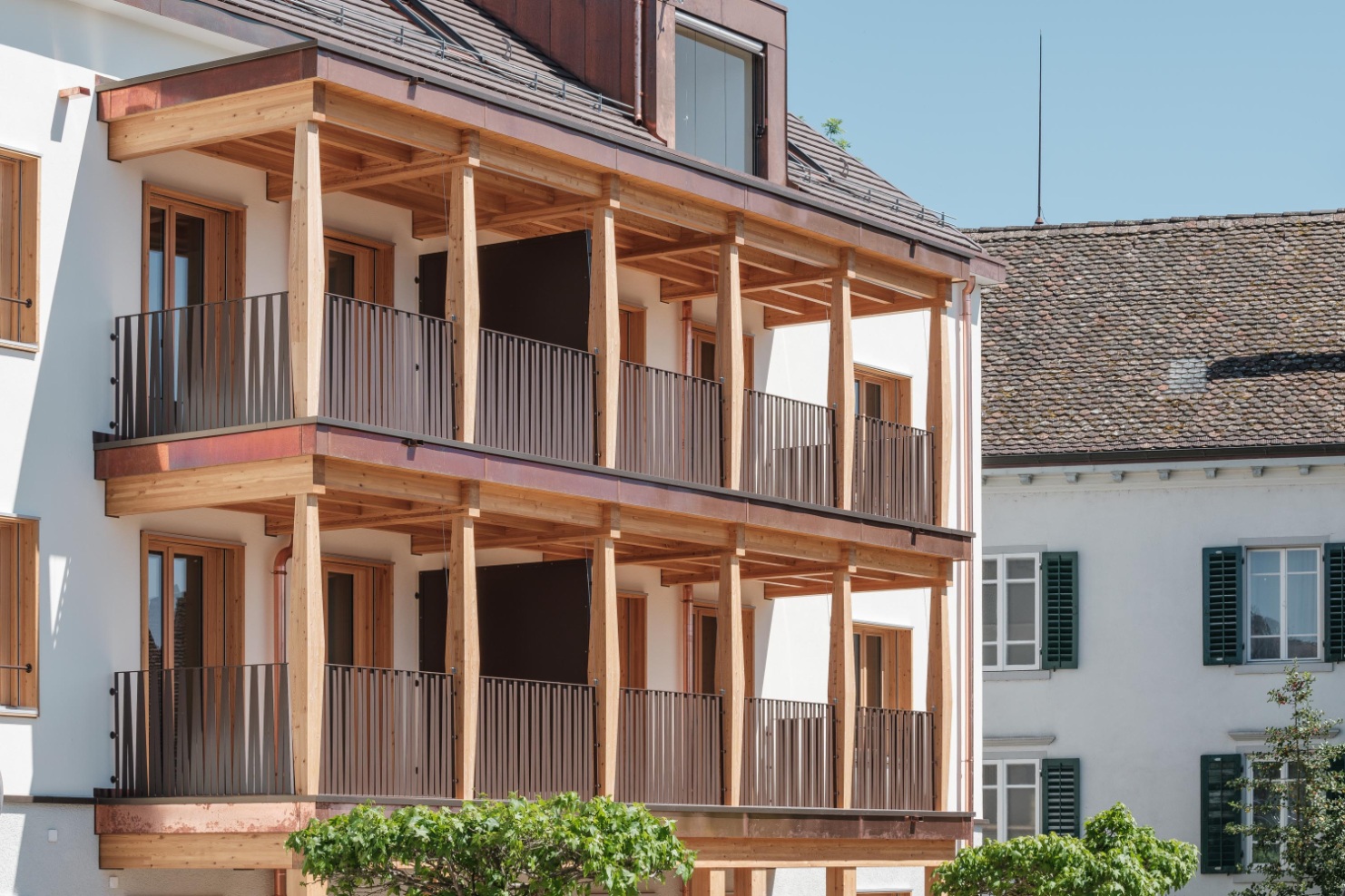 Façade de l’immeuble avec ses balcons caractéristiques en bois et une lucarne dans le toit.