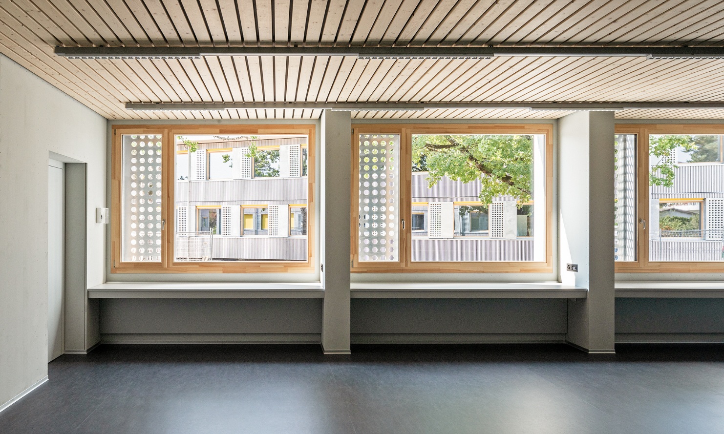 Salles de classe lumineuses avec de grandes fenêtres dans le pavillon scolaire de Brünnen