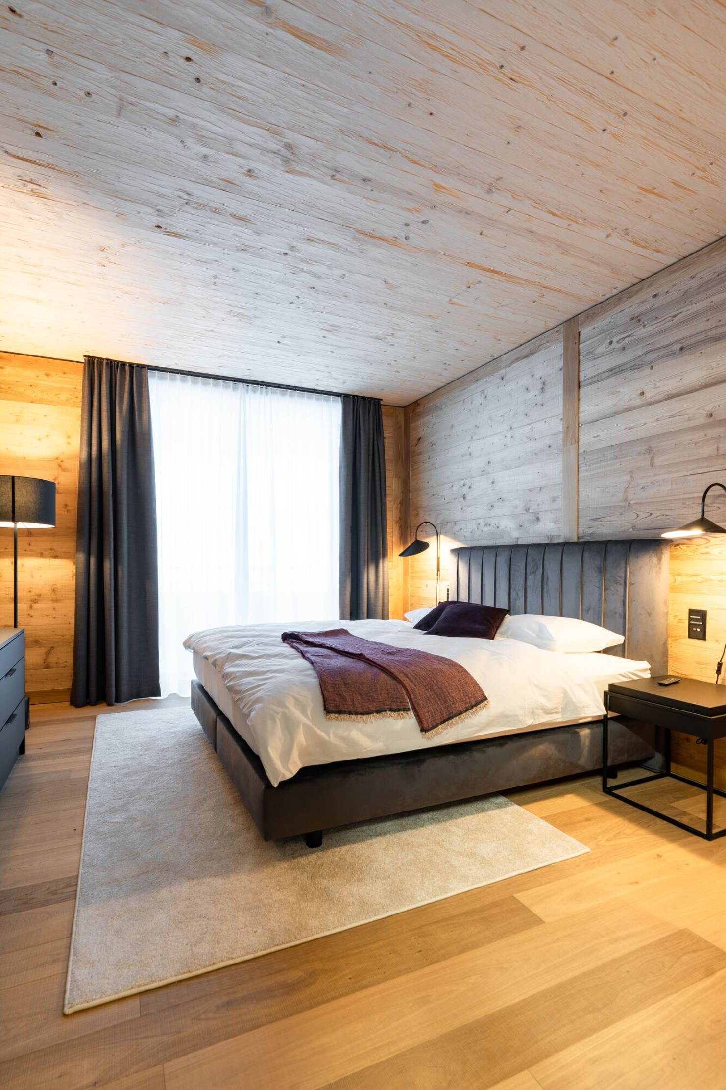 Chambre à coucher avec aménagement intérieur en bois dans une des Turmfalken-Suites