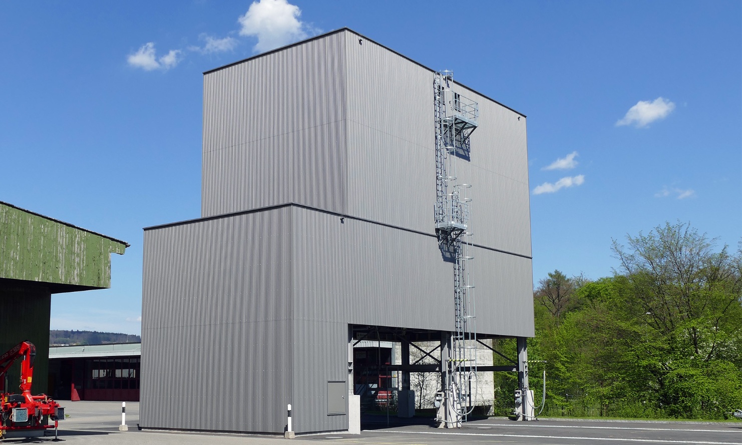 Silo modulaire architectural gris clair de 450 m³ avec échelle en acier placé sur la zone de l’atelier