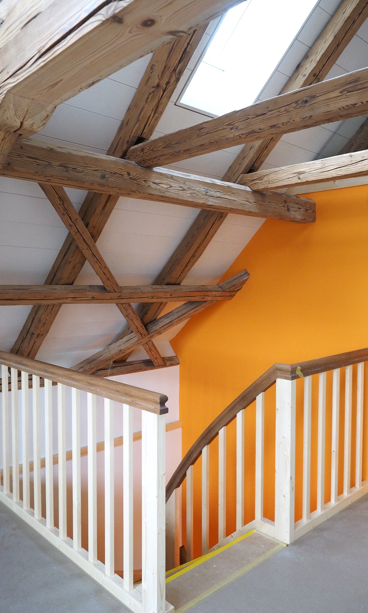 Rohbau vom Treppenaufstieg zum Dachgeschoss des Einfamilienhauses. Das Dach ist komplett verkleidet mit Holzbalken.