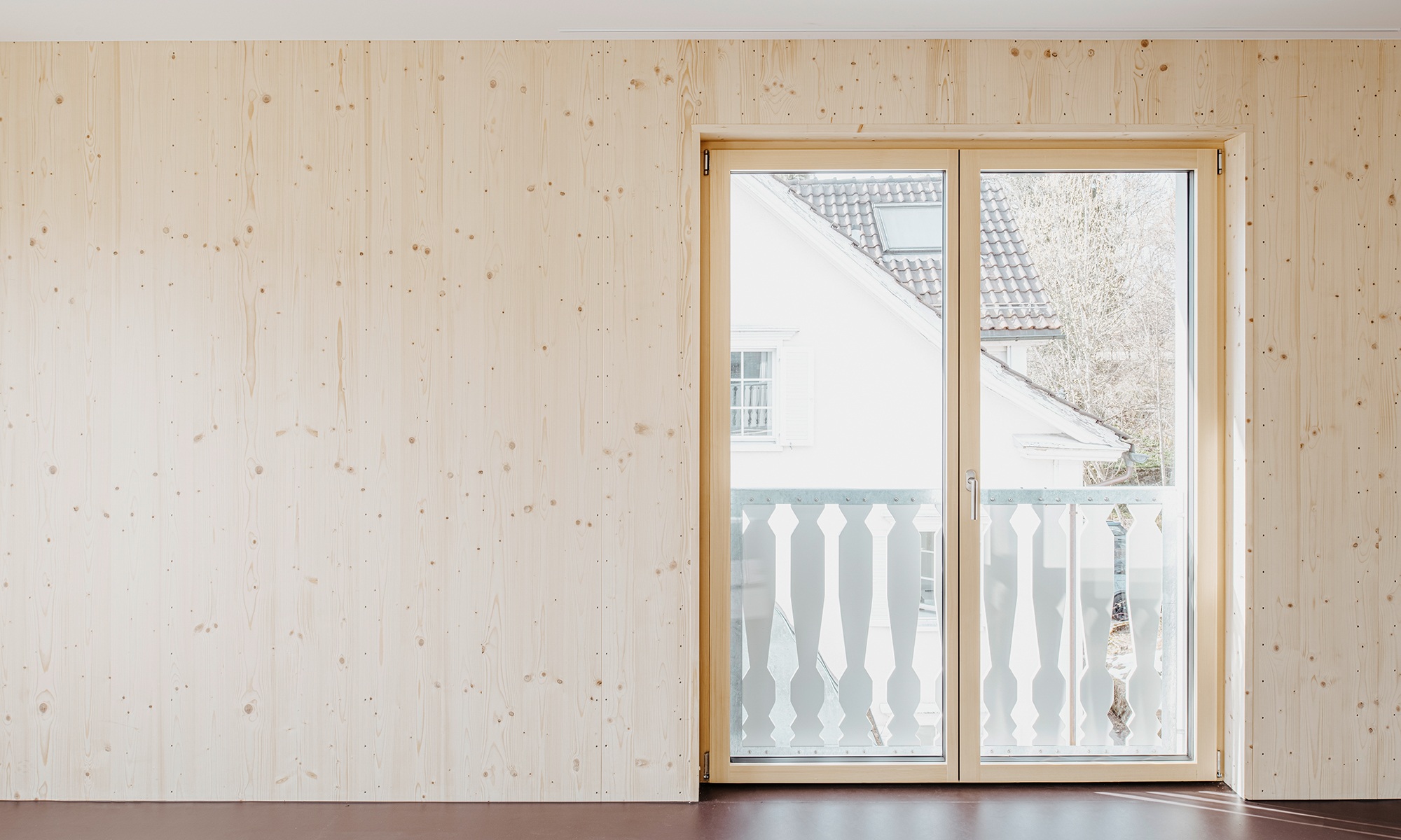 Salon avec mur en bois et portes de balcon