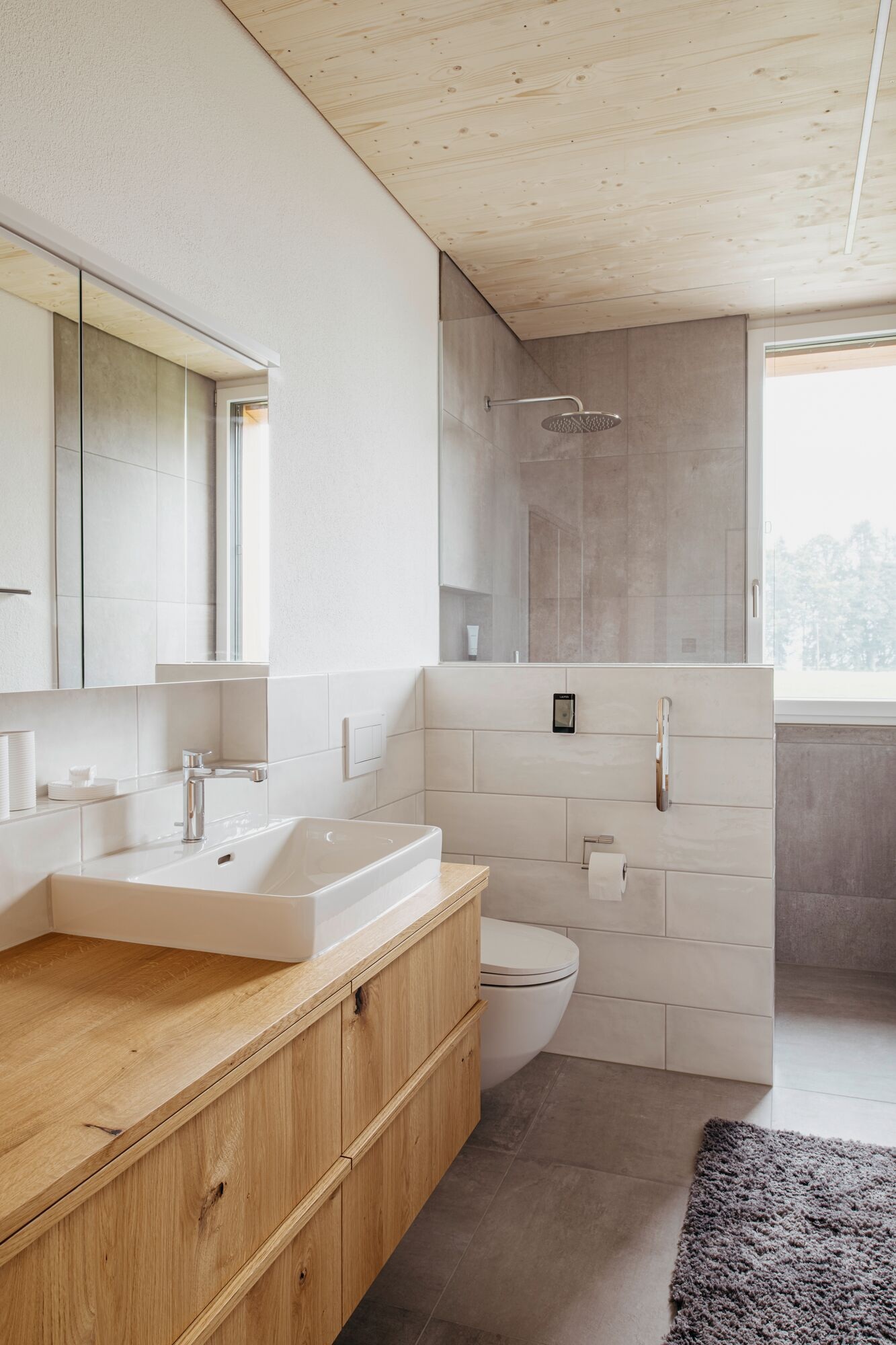 Badezimmer mit grauem Stein, Holz und weissen Elementen