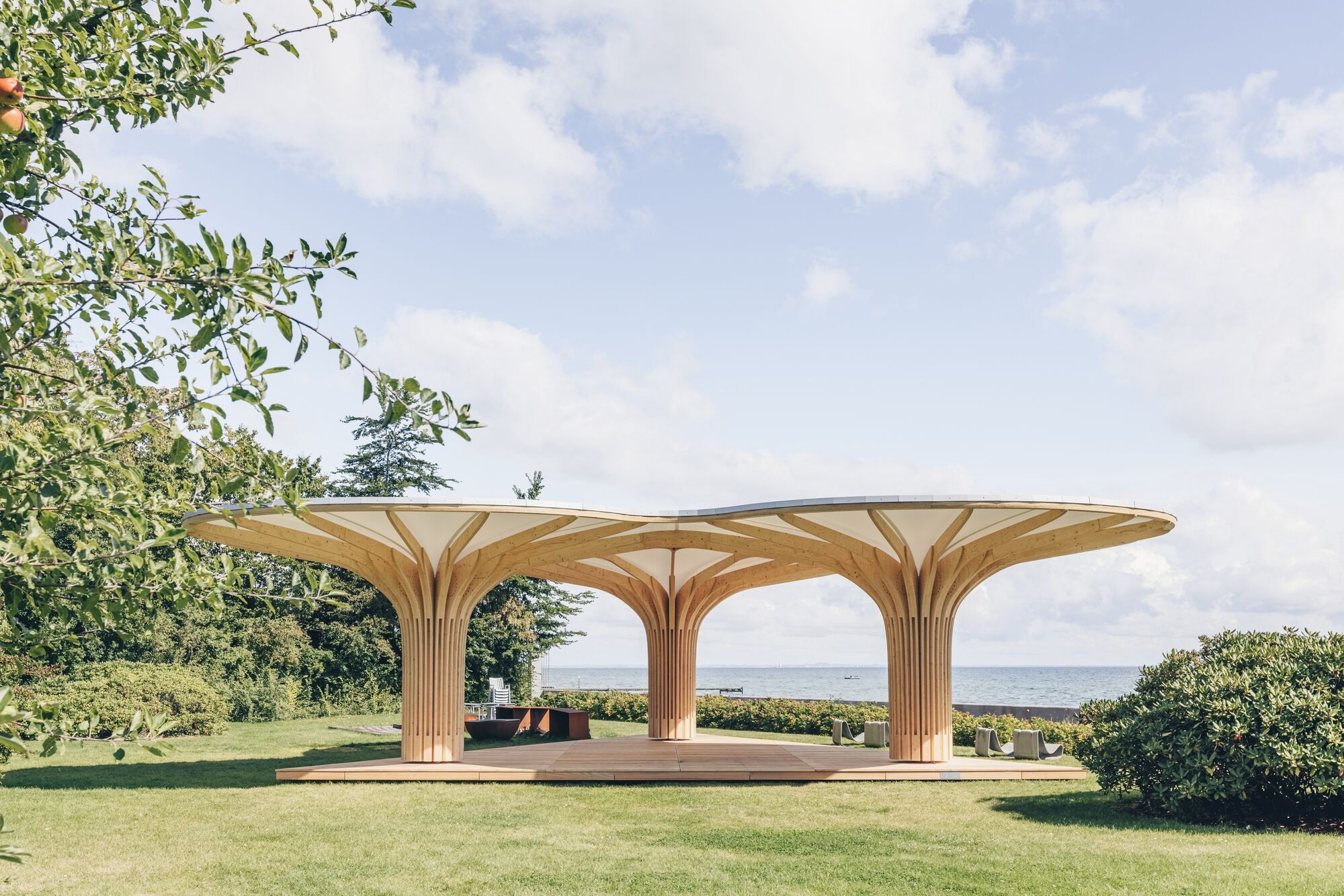 3 holzstrukturen mit membrandach bilden den pavillon „into the woods“