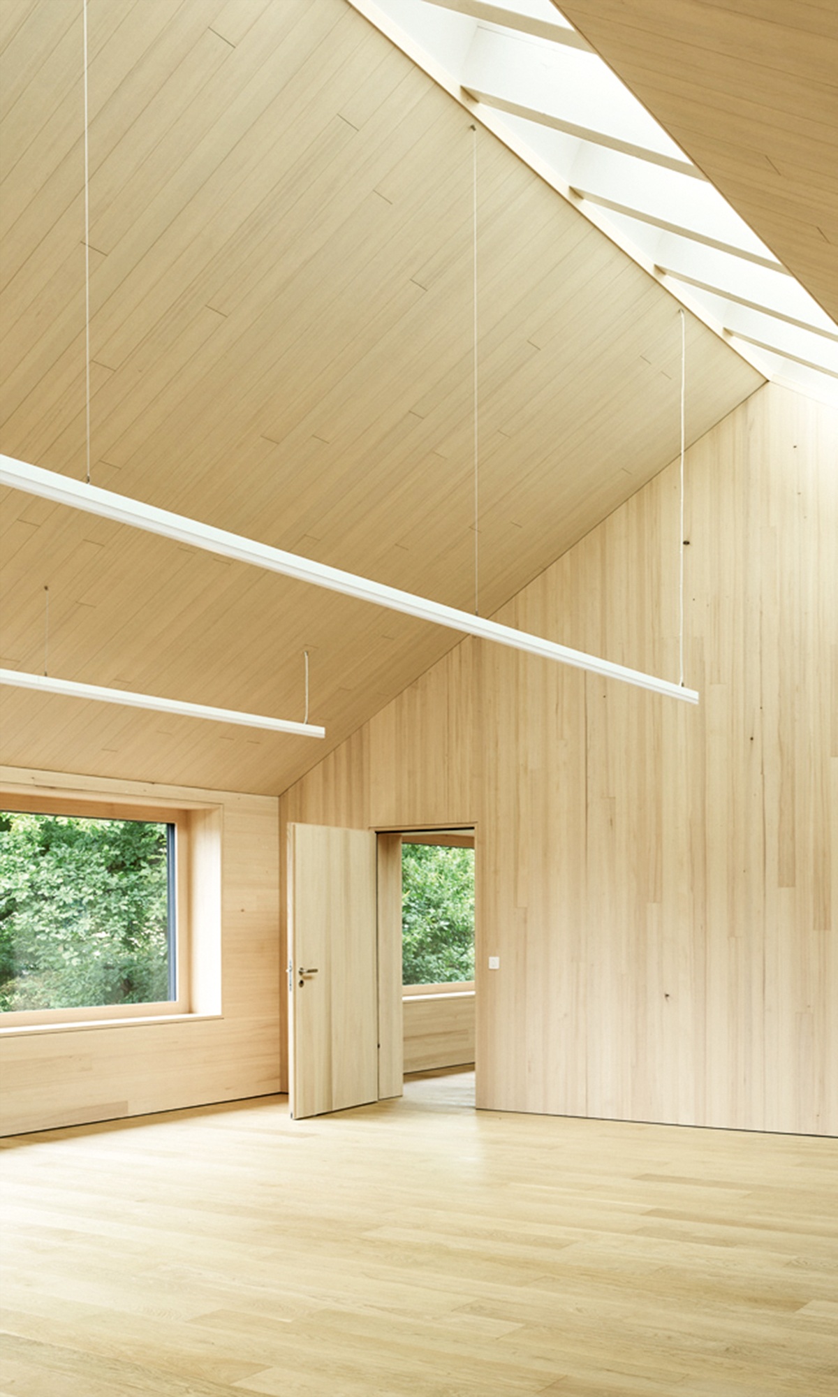 Hoher Raum mit Innenausbau aus Holz und natürlichem Deckenlicht