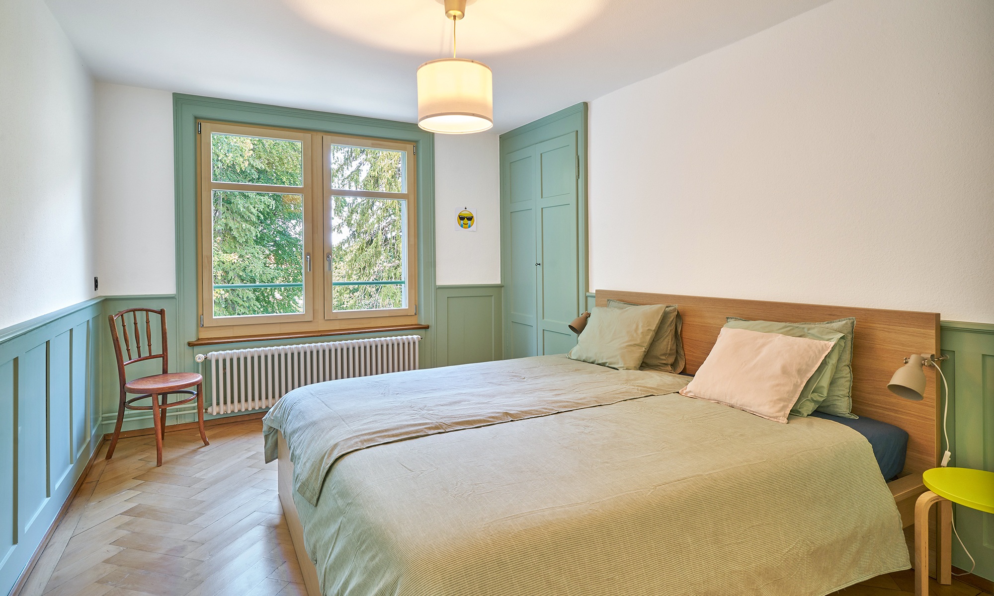 Chambre avec plancher en bois et touches de vert clair