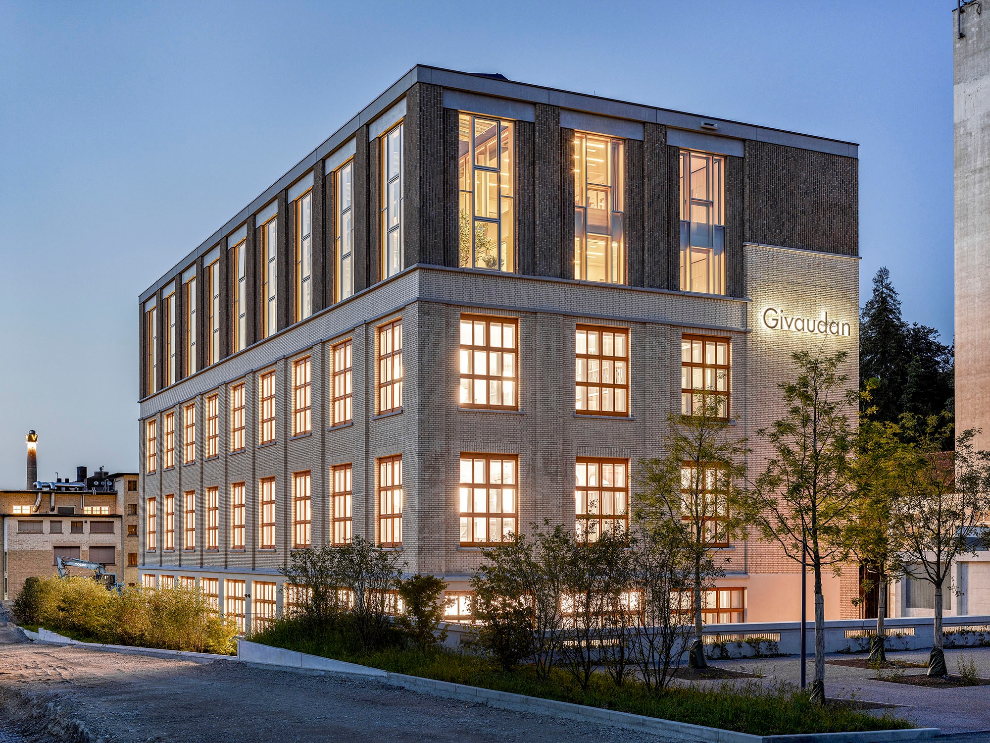 External view of the newly converted Givaudan office building with brightly lit windows