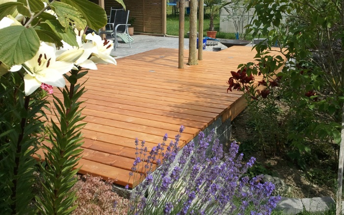 Beautiful wooden terrace with flowers and lavender bush in the foreground