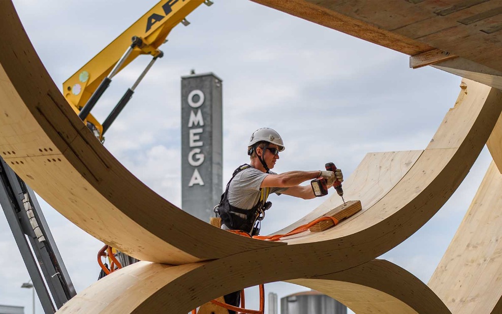 Le collaborateur de montage perce un trou dans la construction en bois du bâtiment Swatch