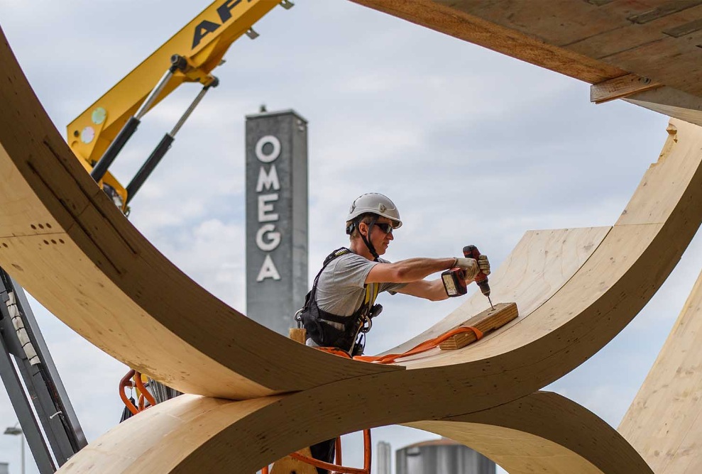 Le collaborateur de montage perce un trou dans la construction en bois du bâtiment Swatch