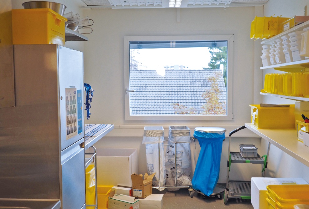 Internal view of a module at the St. Claraspital temporary hospital. The module is used as a storage room. The shelves on the walls contain yellow and white boxes. 
