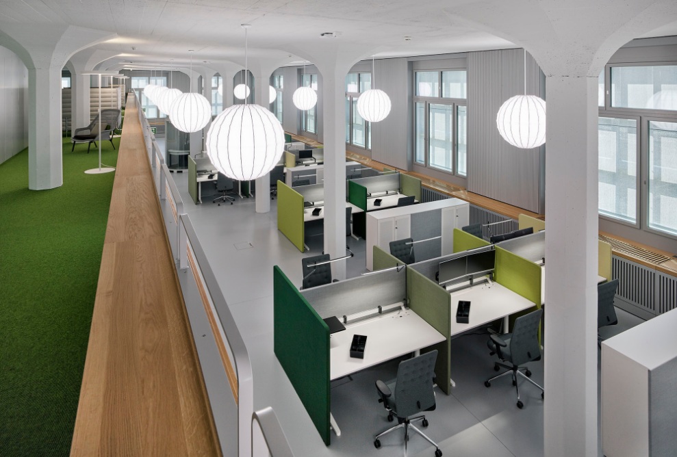 Internal view of the converted factory building: workplaces in the modern open-plan office.