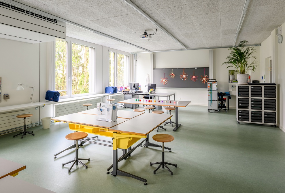 Innenansicht eines Gruppenraumes im Schulhaus Grenzhof Luzern mit Nähmaschine auf dem Tisch