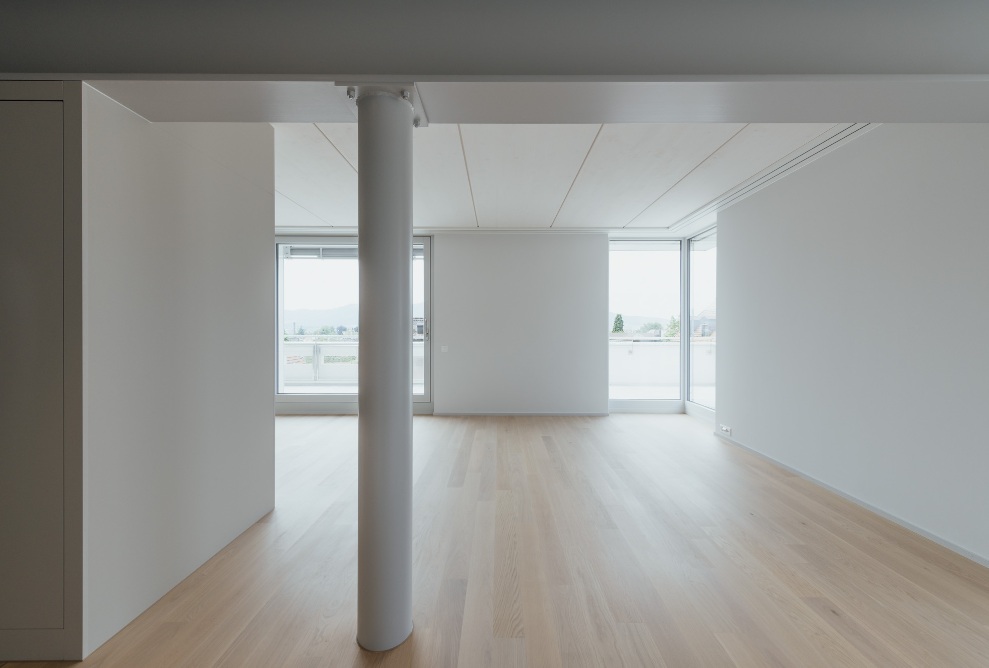 Interior view of the living space with white walls and ceilings and wooden floor 