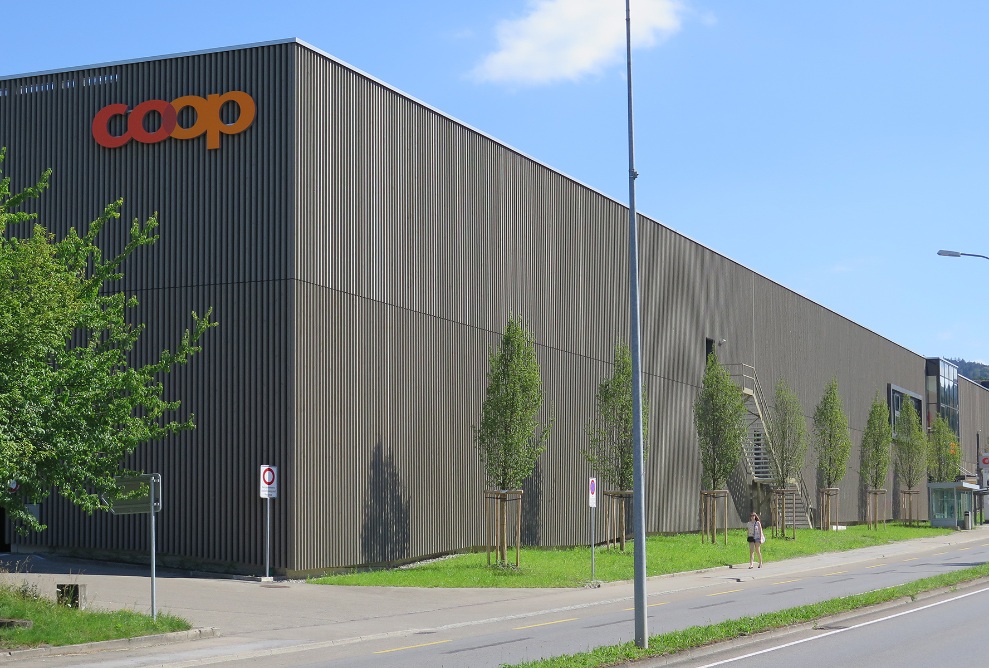 Side view of the renovated Coop Super Center in Uzwil with pre-greyed timber facade.