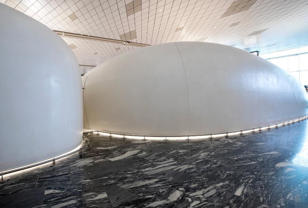 On voit l’arrière d’immenses pavillons à l’aéroport d’Oslo, sur un sol en marbre