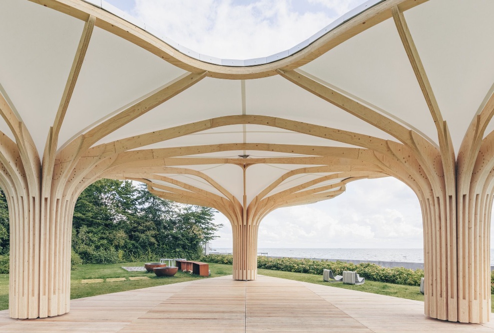 The three timber structures with a textile membrane roof from close up 