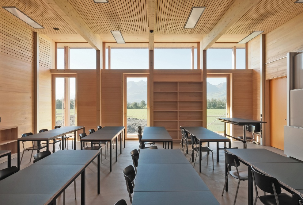 Klassenzimmer der Landwirtschaftlichen Schule Salez mit Holzregalen sowie einer hellen Holzwand und ebenfalls einer Dachstruktur aus Holz