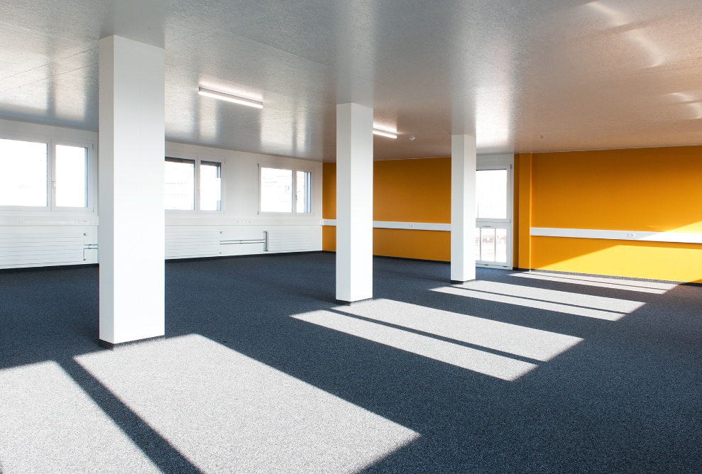 Large space with a yellow wall in the Lausanne transport authority’s temporary office building