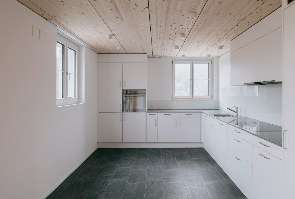 Kitchen with white units and sloping roof 
