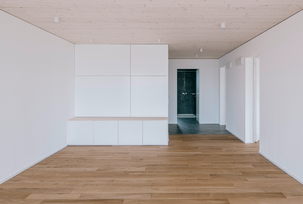 Bright room with wooden floor and wood-concrete composite ceiling 