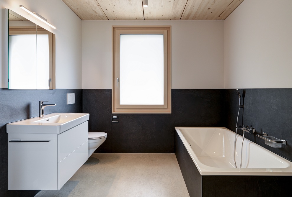 Vue intérieure de la salle de bains avec baignoire, toilettes et lavabo dans un appartement de l’immeuble résidentiel Quellenhof 