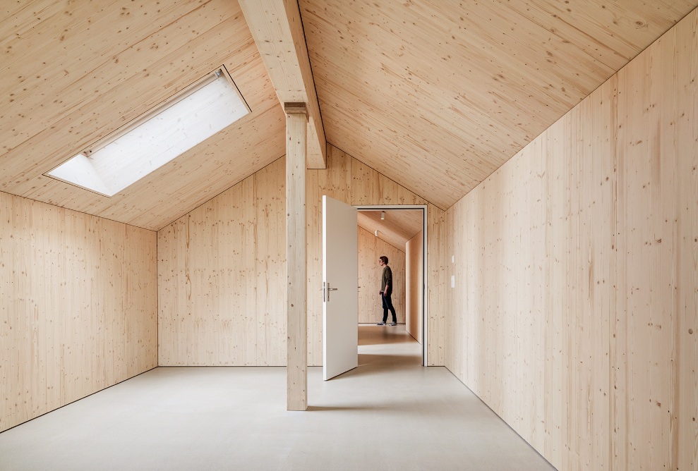 Bright room made entirely of wood, with sloped ceiling and roof window in an apartment in the Quellenhof apartment building